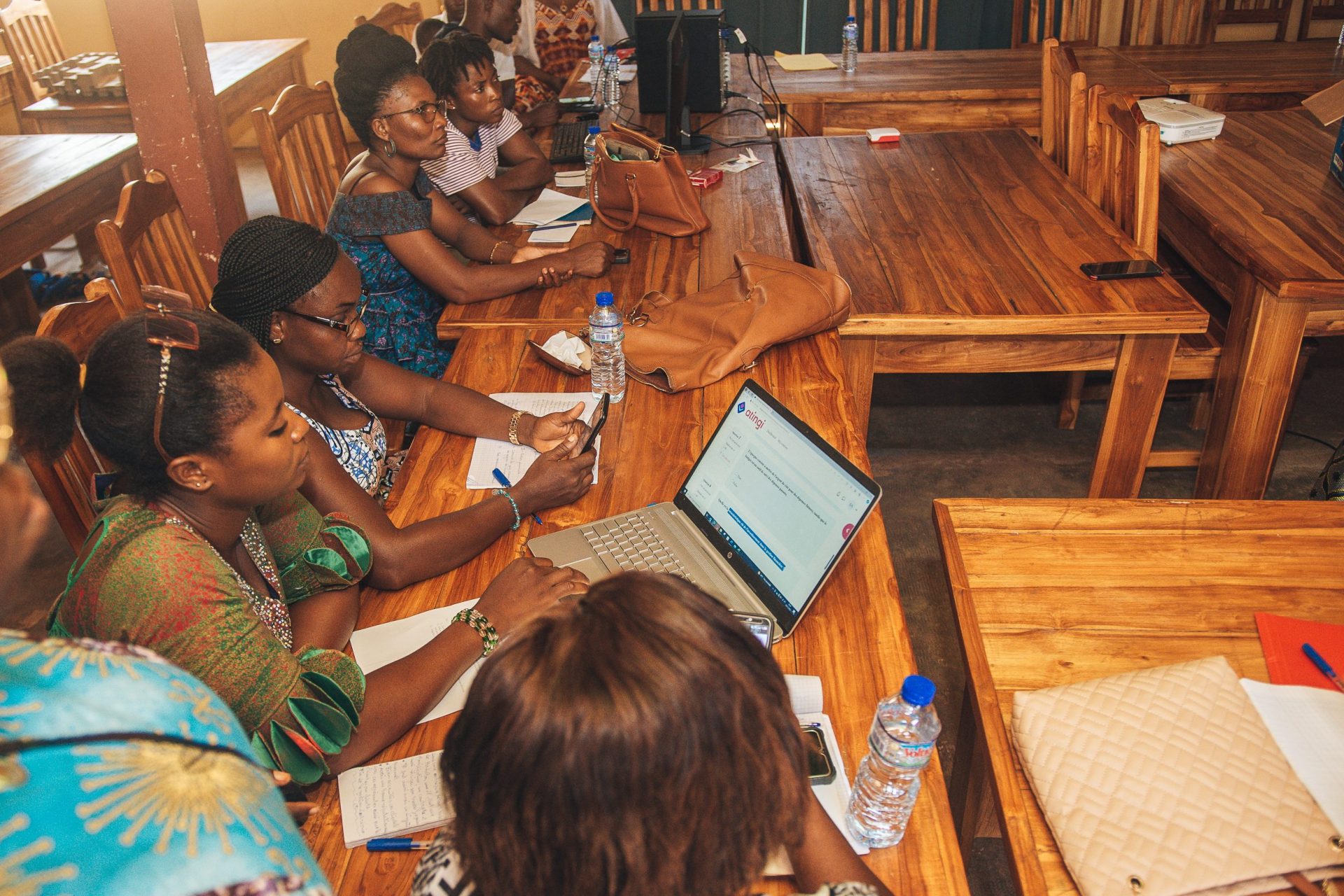 Women taking an atingi course on laptop and mobile devices