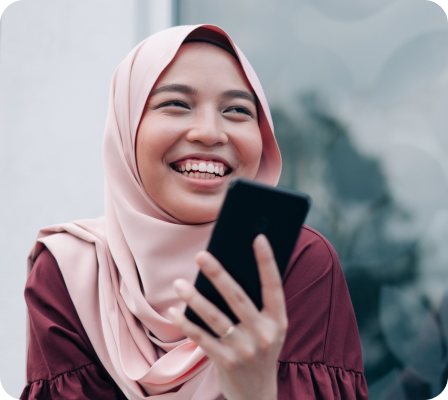 A lady smiling while using her phone.